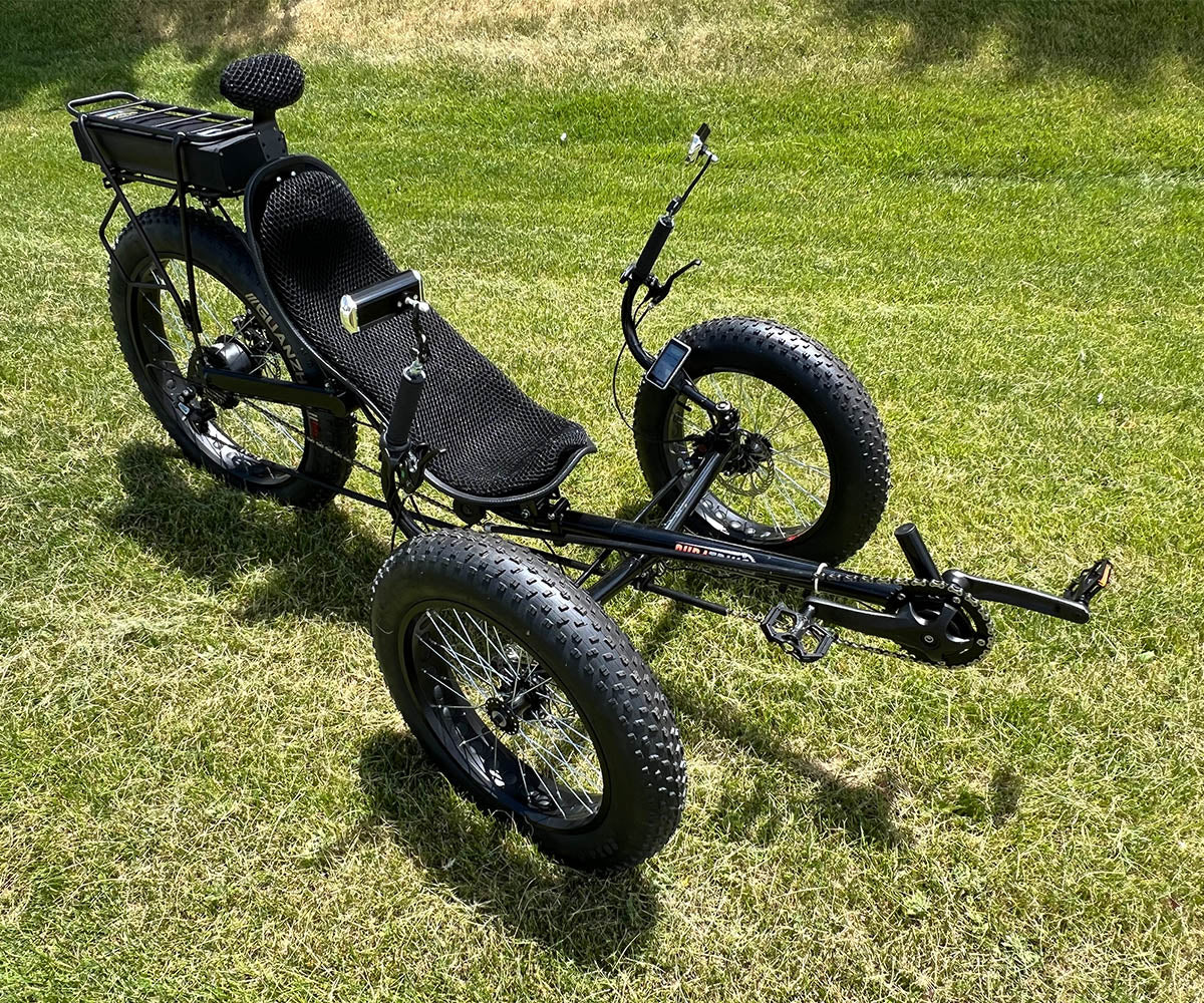 Front angle view DuraTrike FX36e tricycle outside on grass in sunlight.
