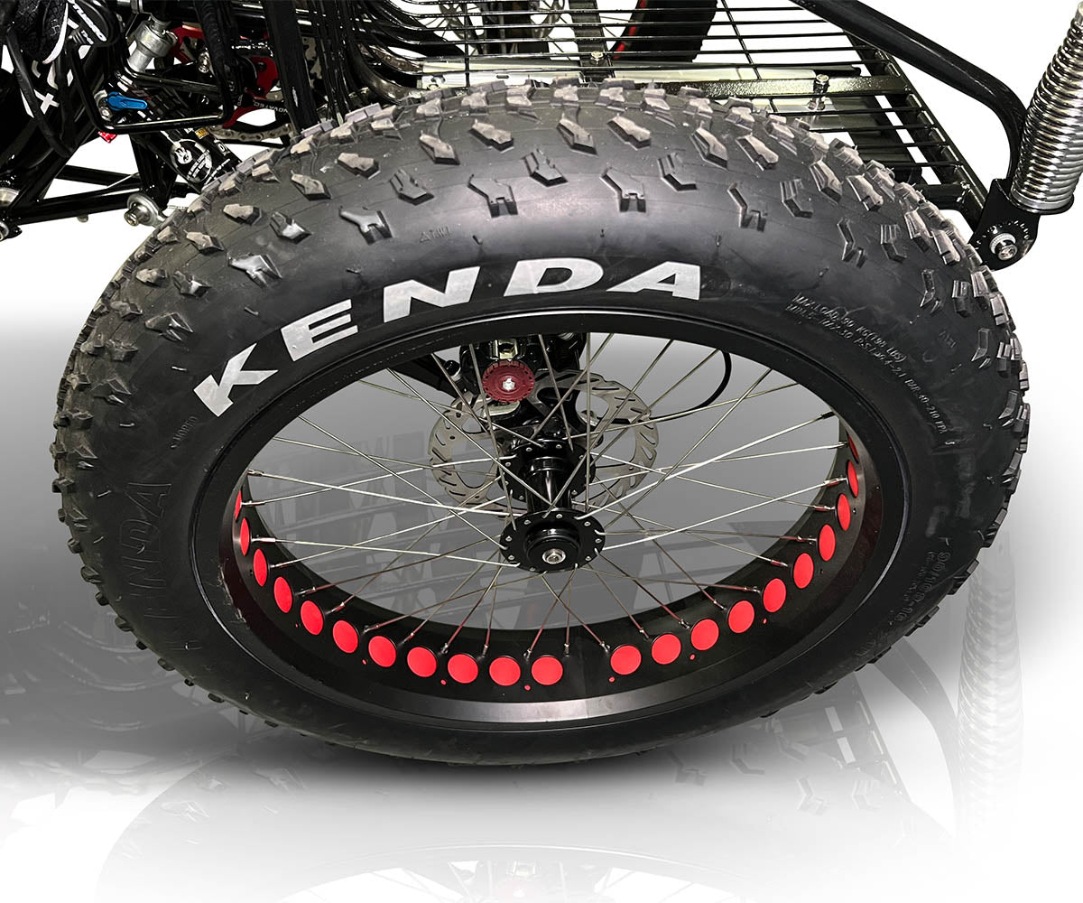 Close-up of a TrikExplor F420E quad with a large Kenda off-road tire and red-accented rim.