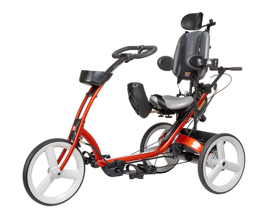 Angled side view of a Rifton X340 with a red frame, headrest, foot pedals, and 18-inch wheels for stability.