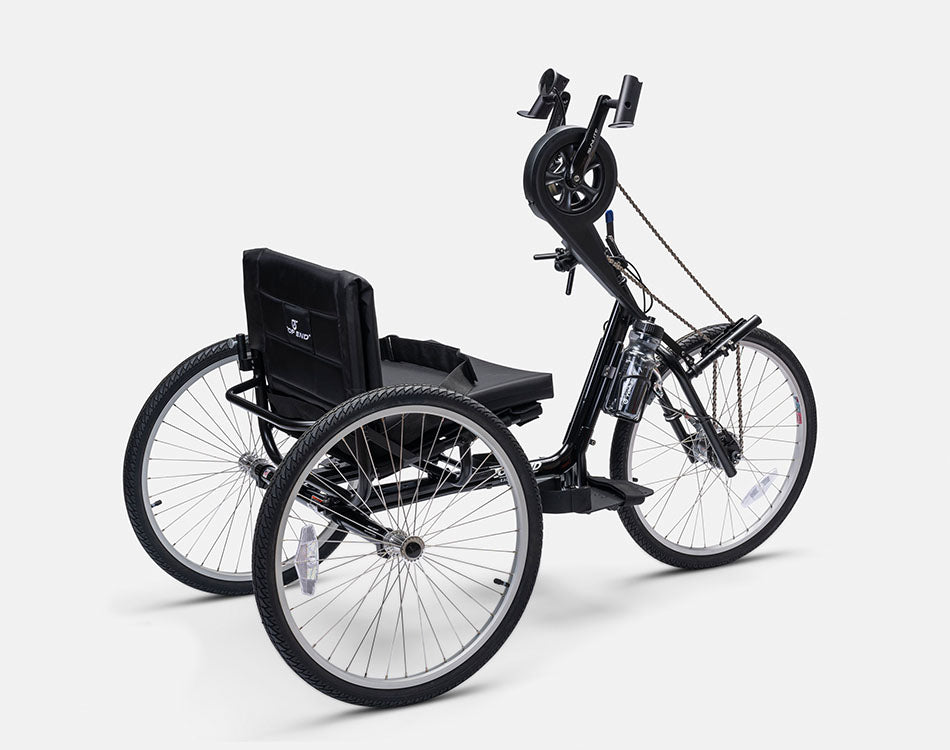 Angled rear view of a Top End Excelerator handcycle with a padded seat, hand pedals, and three large all-terrain wheels.