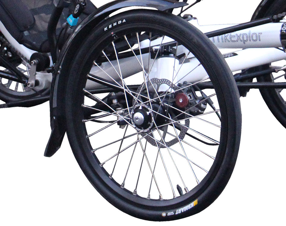 Close up of a smooth touring bike tire with perforated disk brake attached to white frame recumbent trike